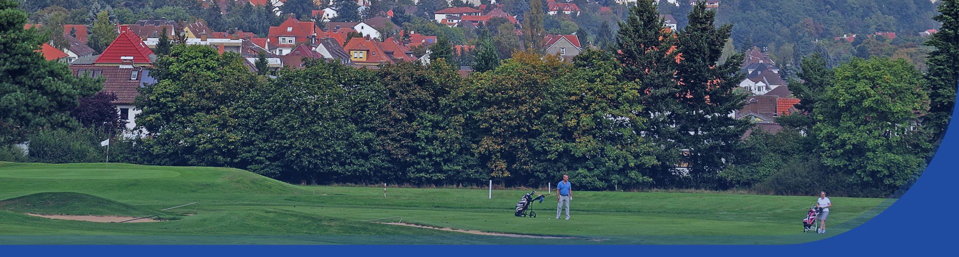Blick aus der Ferne auf zwei Personen die auf einer Golfanlage stehen