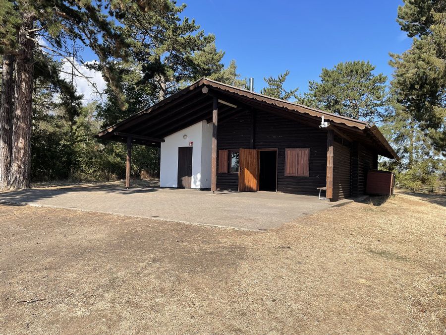 Außenansicht der Grillhütte Busemanns Köppel. Blick auf die Eingangstür und den Außenbereich der Hütte.
