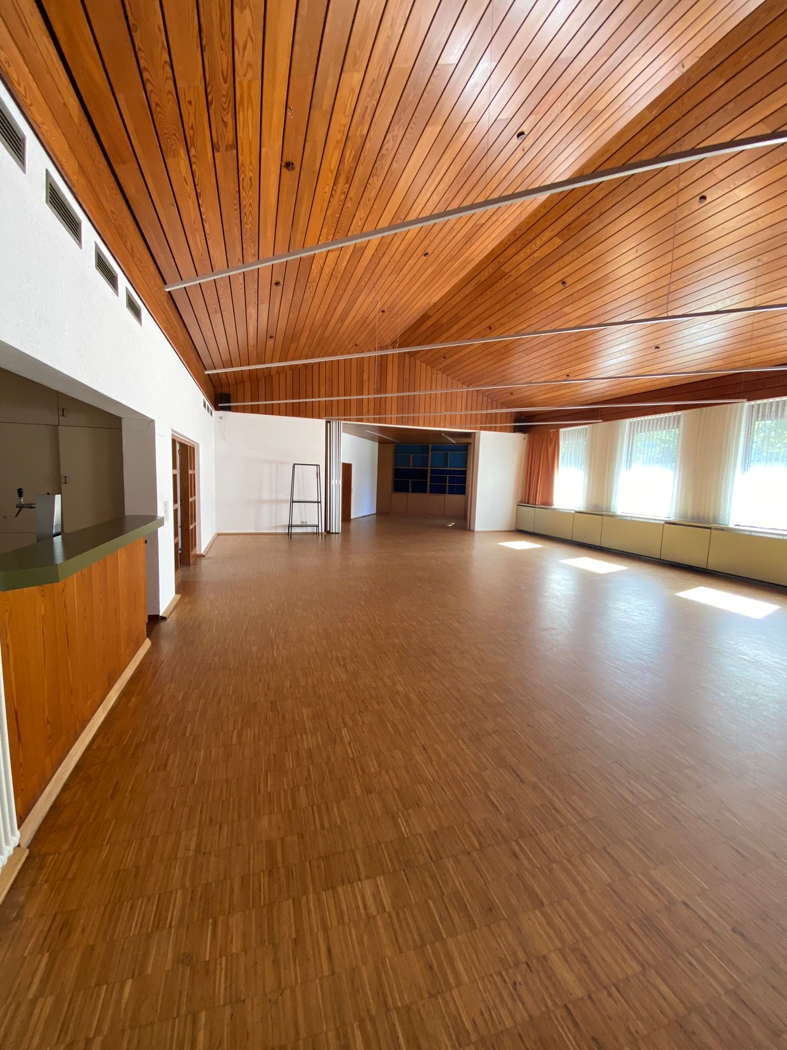 Aufnahme des leeren Saals vom Bürgerhaus Reinhardshausen. Blick auf die Theke und die Erweiterung des Saals.