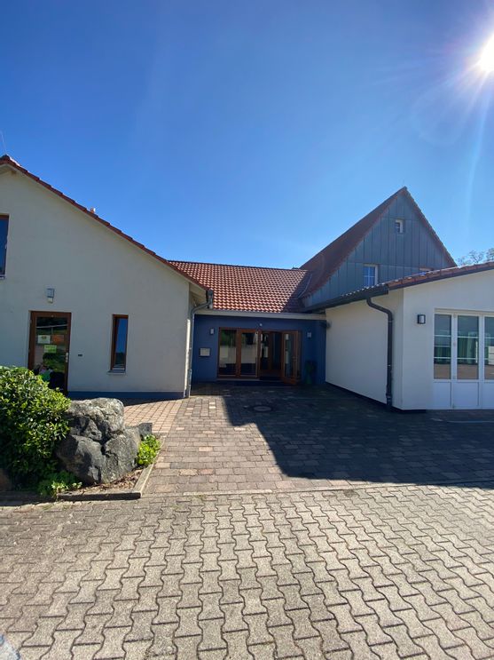Außenaufnahme des Dorfgemeinschaft Haus Armsfeld mit Blick auf die Eingangstür.