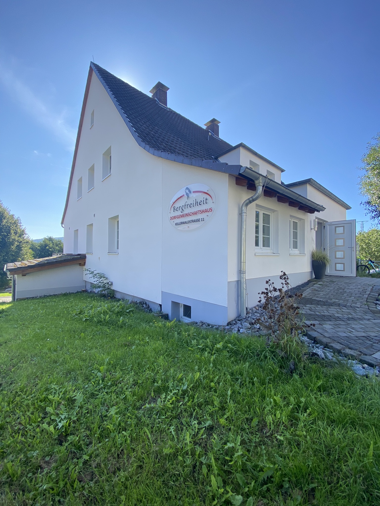 Außenaufnahme des Dorfgemeinschaft Haus Bergfreiheit. Blick auf die Eingangstür.