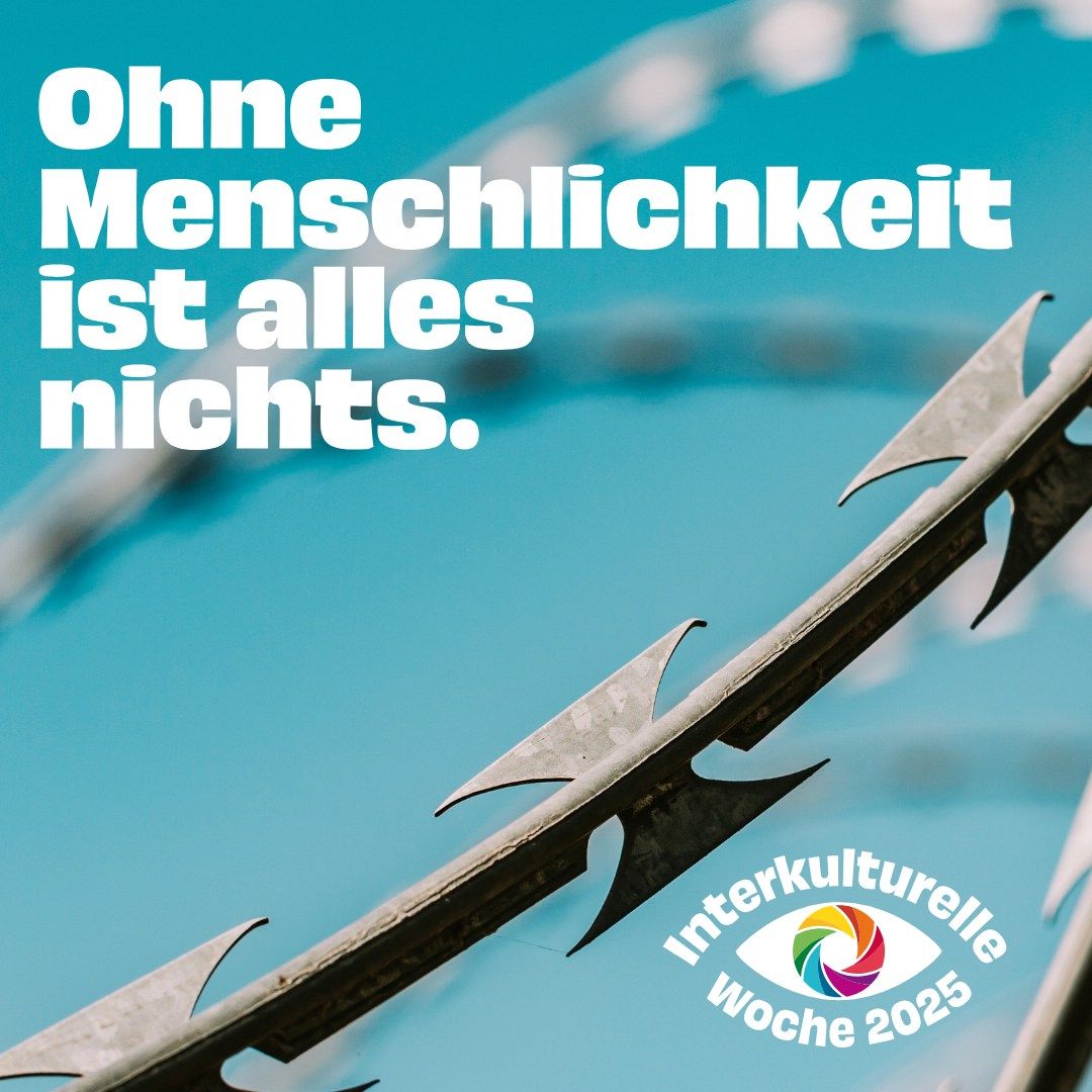 Es ist ein kleiner Teil es Metallzaunes zu sehen. Blauer Hintergrund und der Text Ohne Menschlichkeit ist alles nichts. Unten rechts ist das Logo Interkulturelle Woche 2025 zu sehen.