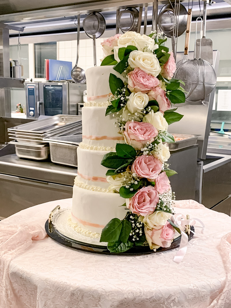 Vierstöckige Hochzeitstorte mit eleganter Rosendekoration – kunstvoll gestaltetes Highlight für eine romantische Hochzeitsfeier.