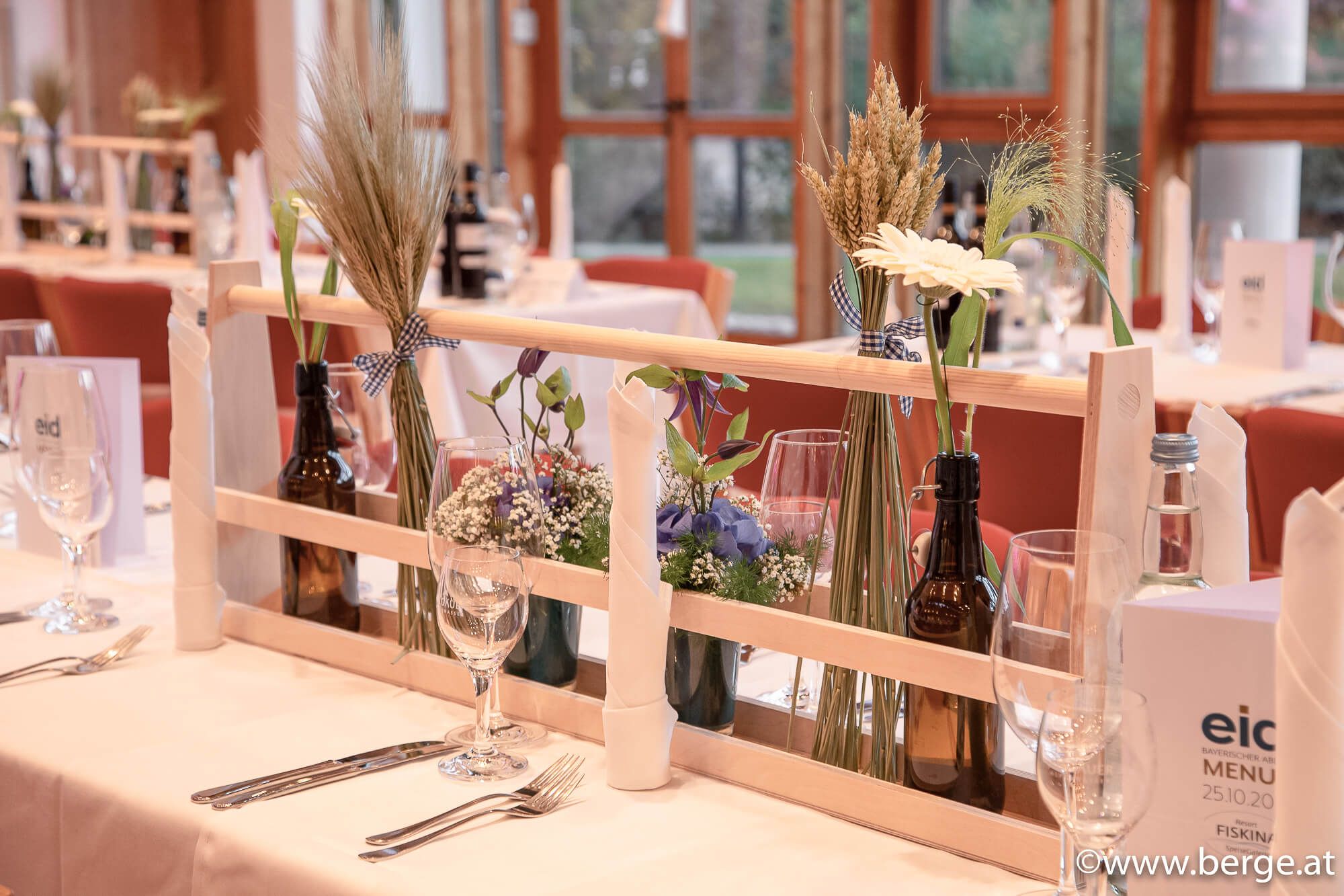 Dekorativ gedeckter Tisch mit frischen Blumenarrangements – einladendes Ambiente für festliche Anlässe und gemütliche Zusammenkünfte.