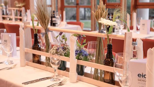 Dekorativ gedeckter Tisch mit frischen Blumenarrangements – einladendes Ambiente für festliche Anlässe und gemütliche Zusammenkünfte.