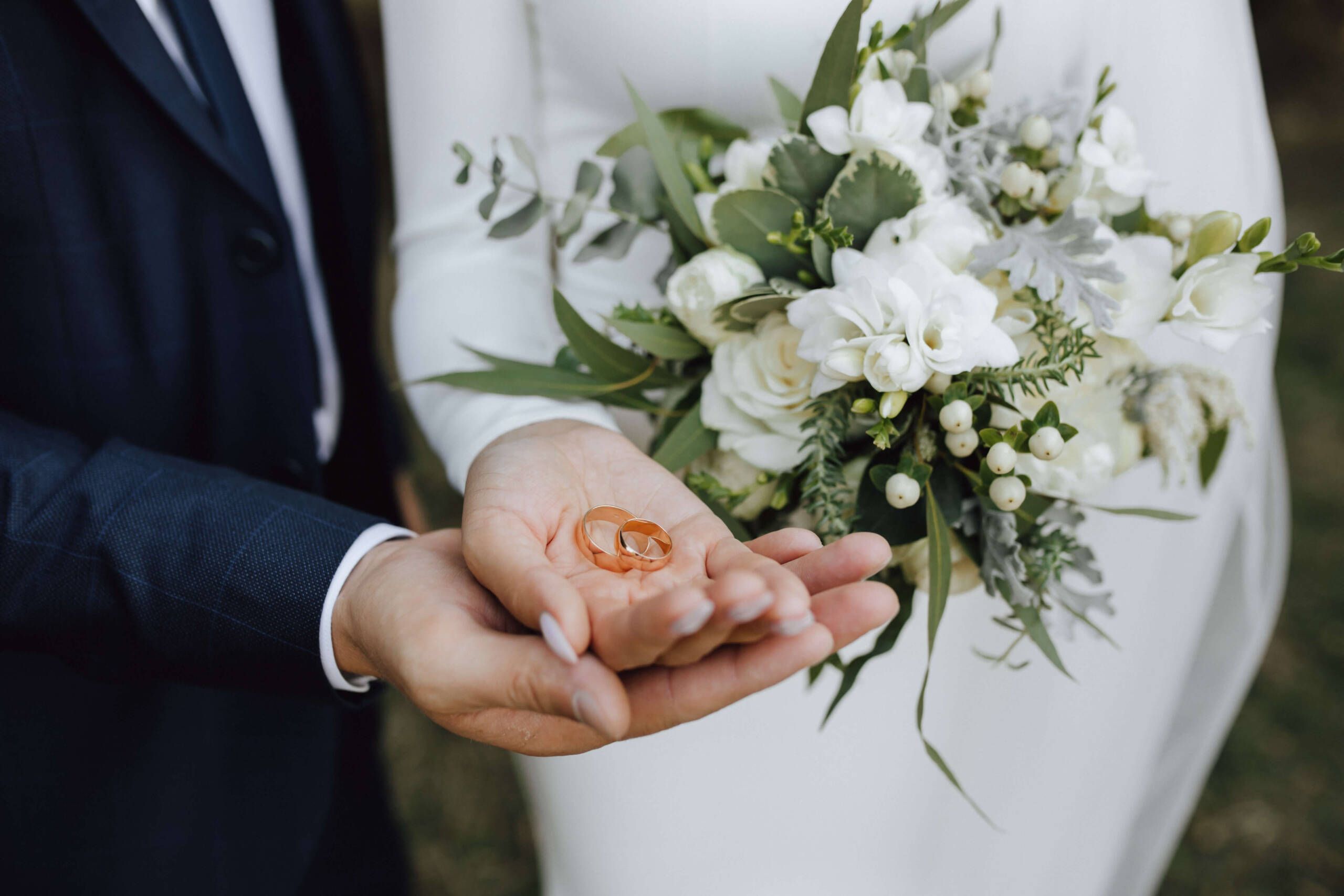 Hochzeit: Ehepaar hält Eheringe in den Händen – symbolischer Moment der Liebe und Zusammengehörigkeit an ihrem besonderen Tag.