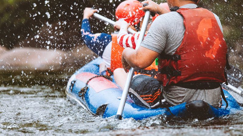 Menschen beim Rafting auf einem wilden Fluss – actionreicher Outdoor-Sport und Abenteuer inmitten unberührter Natur.