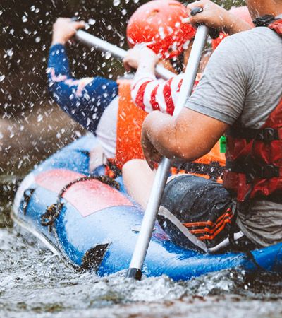 Menschen beim Rafting auf einem wilden Fluss – actionreicher Outdoor-Sport und Abenteuer inmitten unberührter Natur.