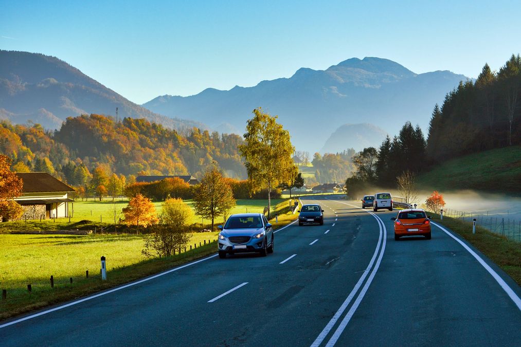 Straße in Fischen im Allgäu mit Blick auf traditionelle Häuser und Alpenkulisse – idyllischer Ortskern inmitten der Allgäuer Berglandschaft.