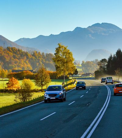 Straße in Fischen im Allgäu mit Blick auf traditionelle Häuser und Alpenkulisse – idyllischer Ortskern inmitten der Allgäuer Berglandschaft.