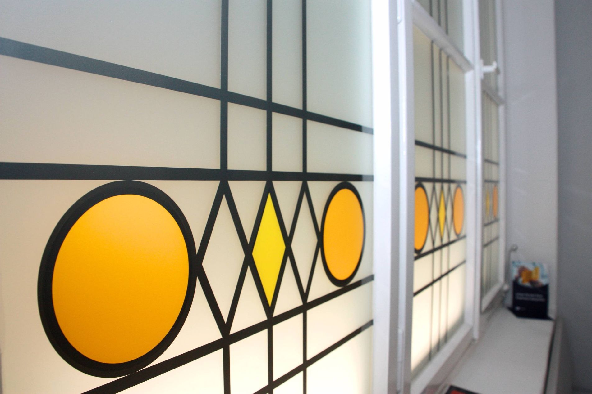 Praxisflur mit Sitzbank und bunt verglastem Fenster