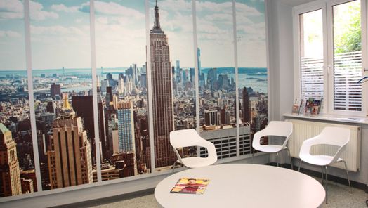 Wartezimmer mit großformatiger New York Fotowand, runder Tisch und drei Stühle