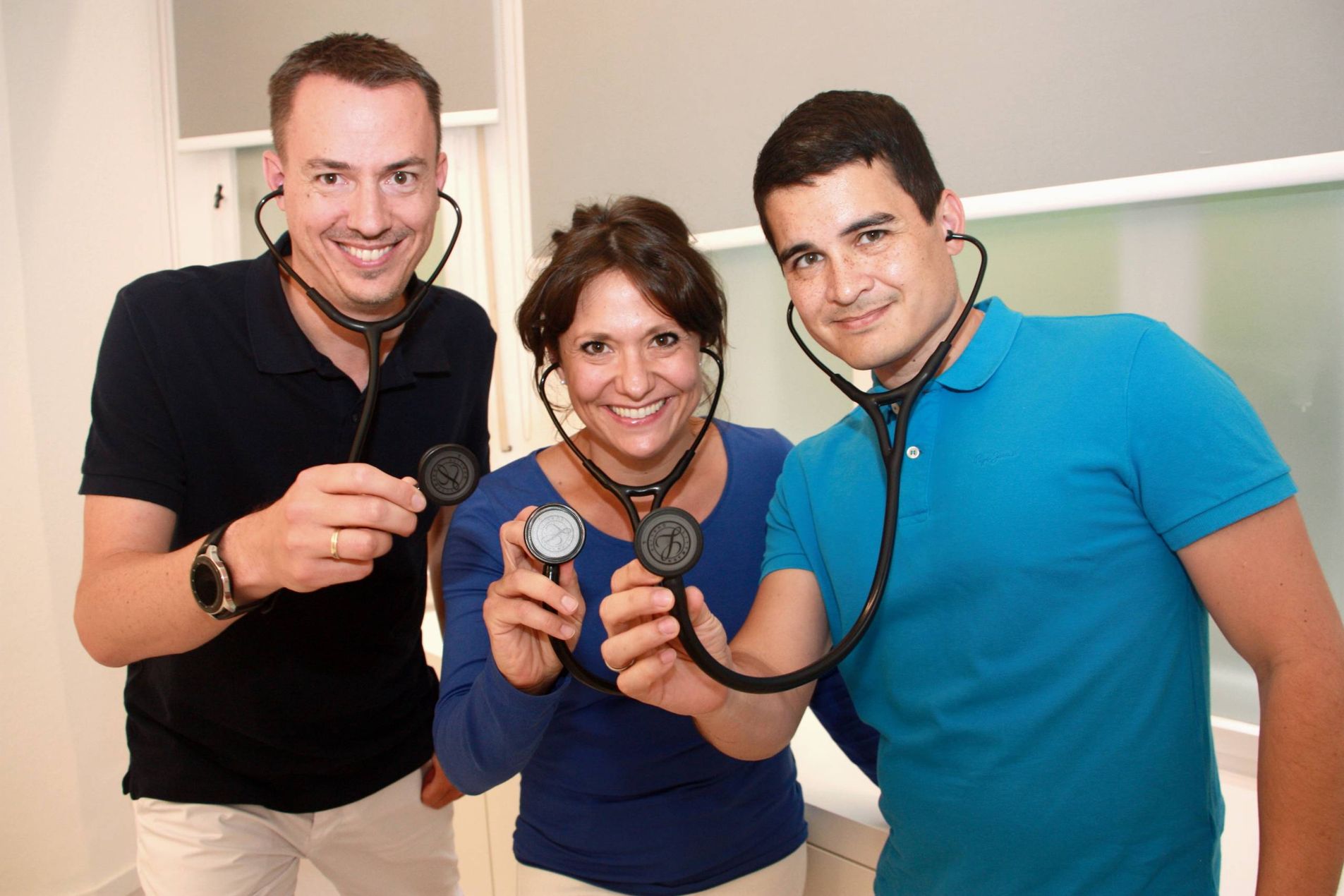 Ärzteteam im Sprechzimmer, Stethoskope in den Händen
