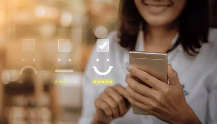 Eine Frau gibt ihr Online-Feedback am Smartphone ab.