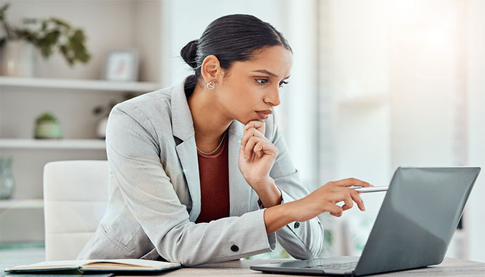 Eine Frau sitzt am Laptop und arbeitet mit der Befragungssoftware.