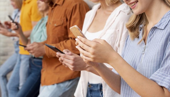 Mehrere Menschen sind am Smartphone und geben einen CES ab.