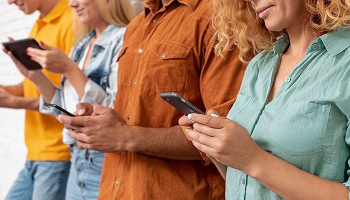 Mehrere Menschen sind am Smartphone und füllen eine Internationale Kundenbefragung aus.