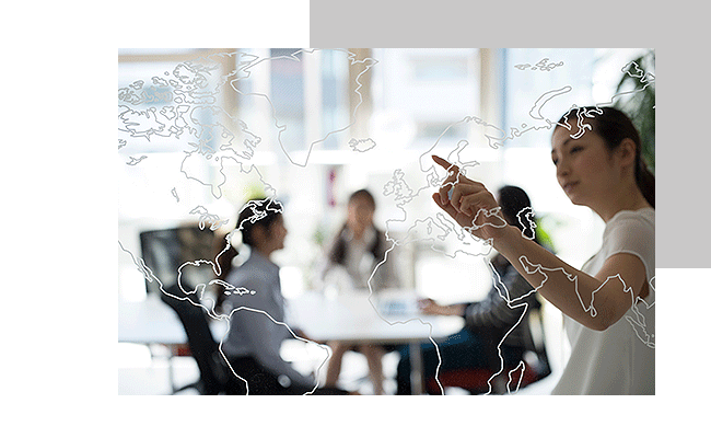 Eine Frau zeigt auf einer gläsernen Weltkarte das Land, welches für die Internationales Kundenfeedback ausgewählt wurde.