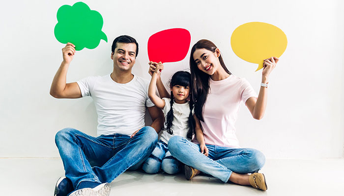 Eine Familie hält Sprechblasen in den Händen.