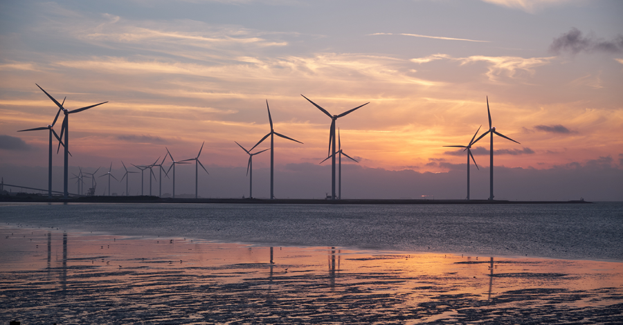 Photo of wind turbines at sunset