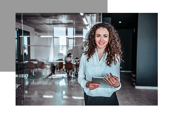 Eine Führungskraft ist im Büro mit einem Tablet in der Hand.