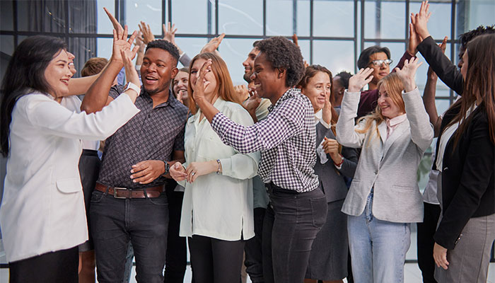 A successful employee experience in practice: employees celebrate and cheer together.