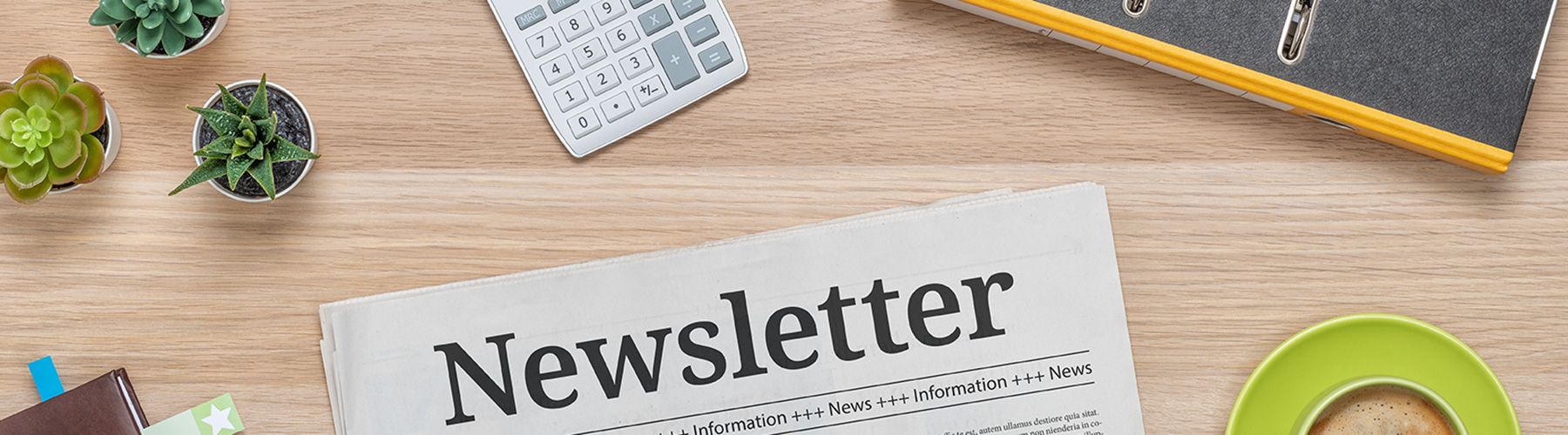 Eine Zeitung mit der Überschrift Newsletter liegt auf einem Tisch.