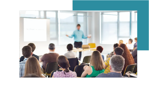 A group of people is listening to the speaker during a training session about software.