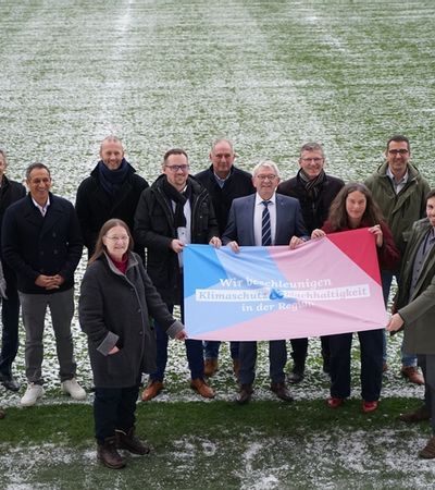 Mitglieder des Klimafonds stehe zusammen und halten PLakat.