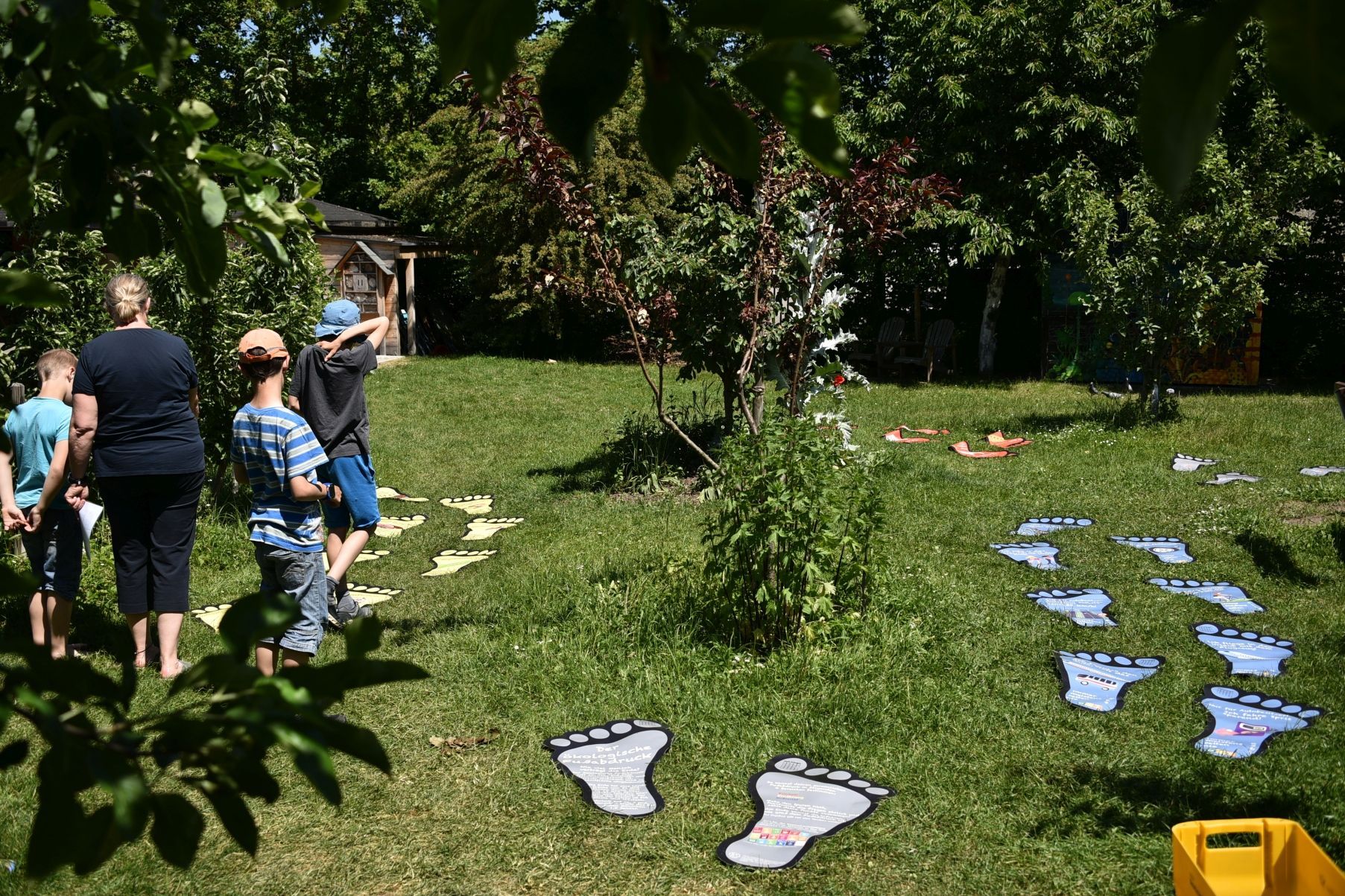 Kinder machen einen Klimapfad auf einer grünen Wiese