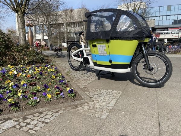 Lastenrad der Stadt Erlangen vor Blumenbeet