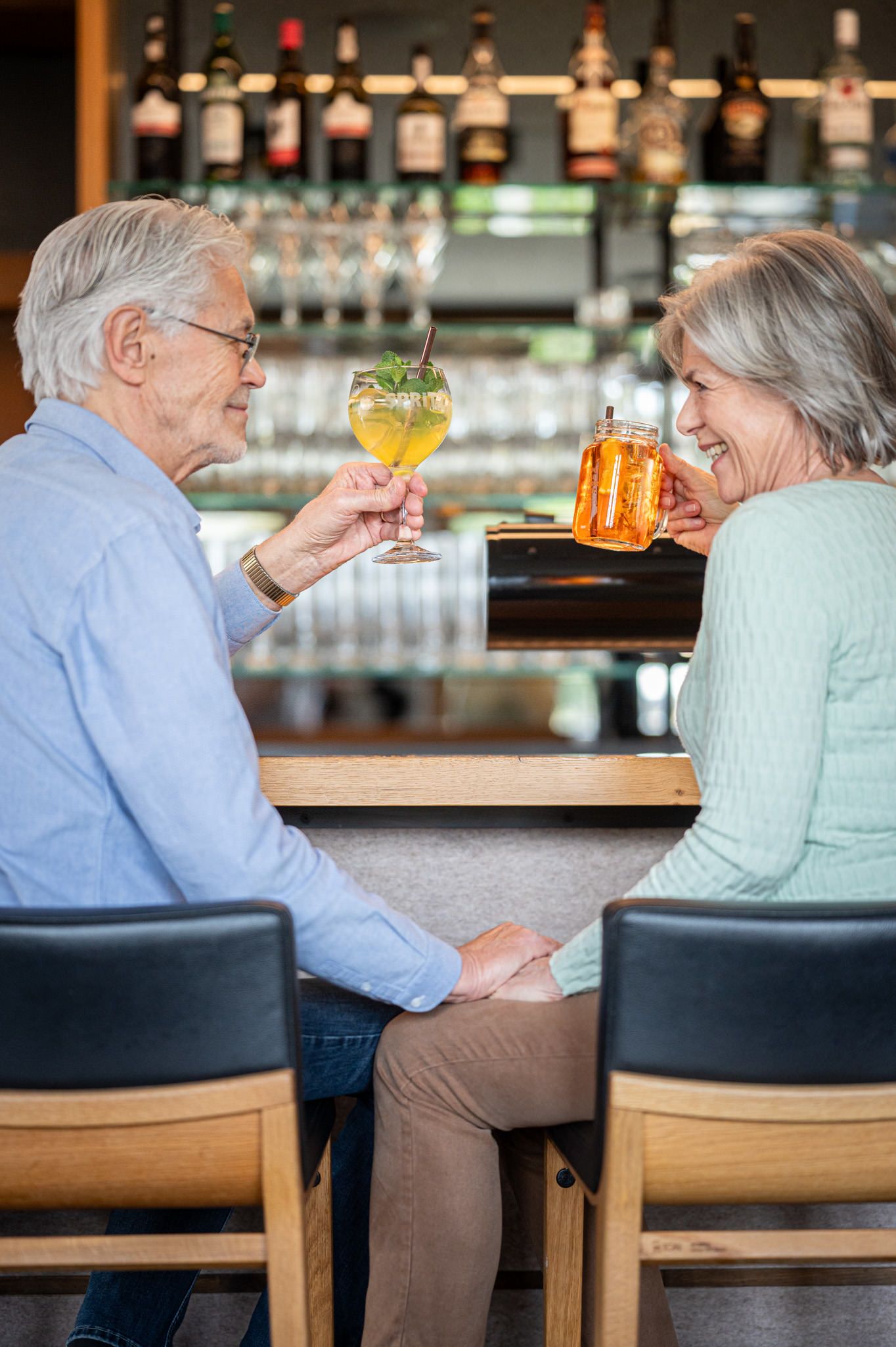 Seniorenpaar sitzt an der Bar der Speisegalerie und genießt ein leckeres Getränk in gemütlicher Atmosphäre.