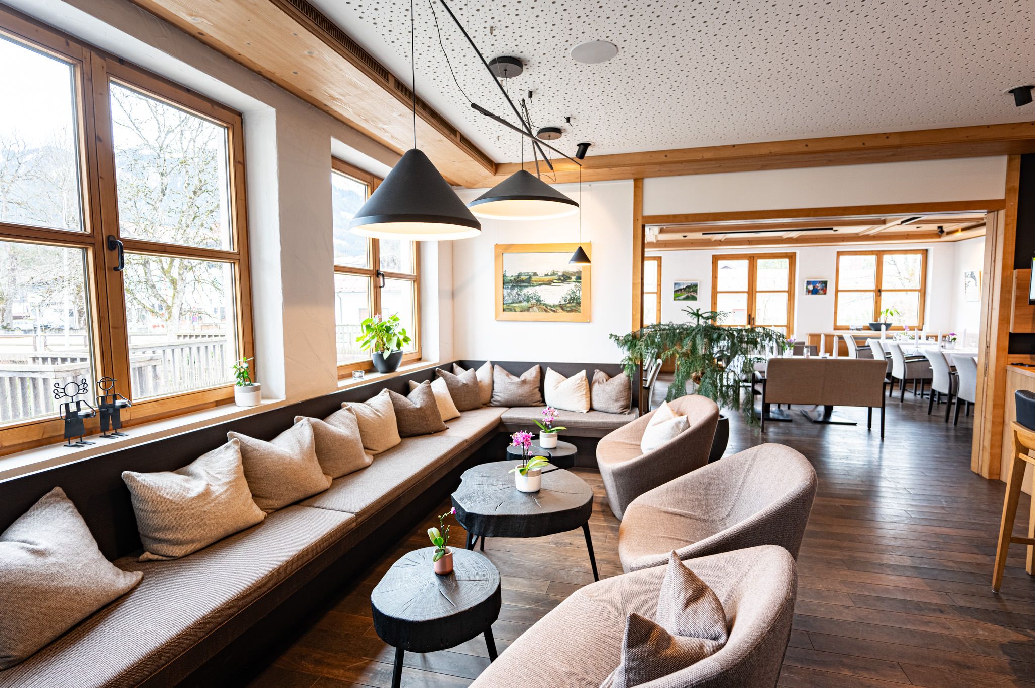 Gemütliche Sitzecke mit grauen Polstermöbeln und kleinen Tischen – stilvolles, modernes Ambiente in der Speisegalerie Fischen, ideal zum Verweilen und Genießen.