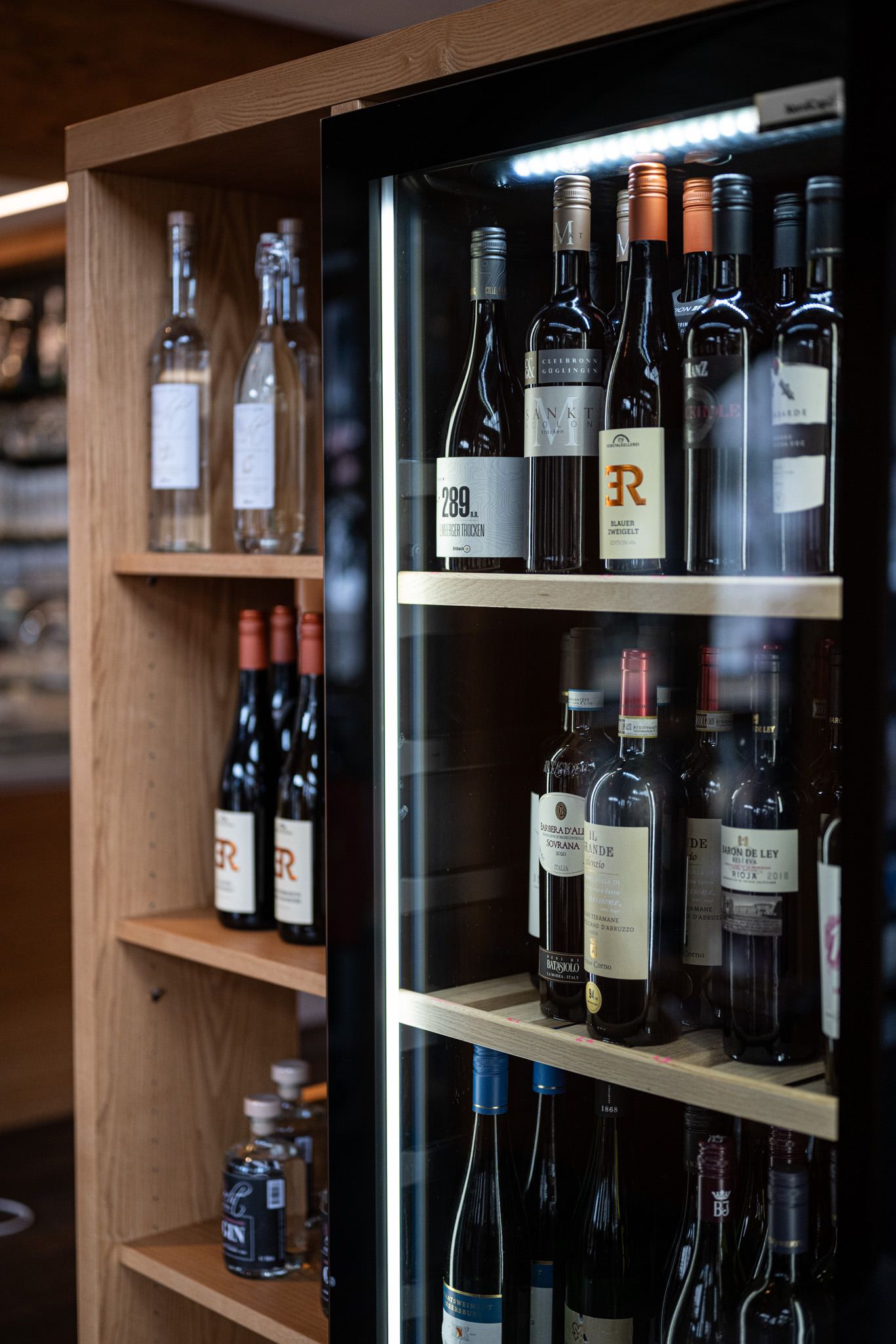Verschiedene Weine in Flaschen präsentiert in der Speisegalerie, bereit für den Genuss.