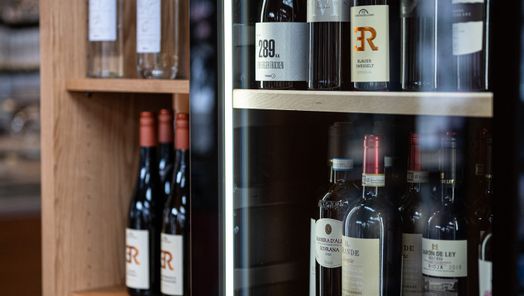 Verschiedene Weine in Flaschen präsentiert in der Speisegalerie, bereit für den Genuss.