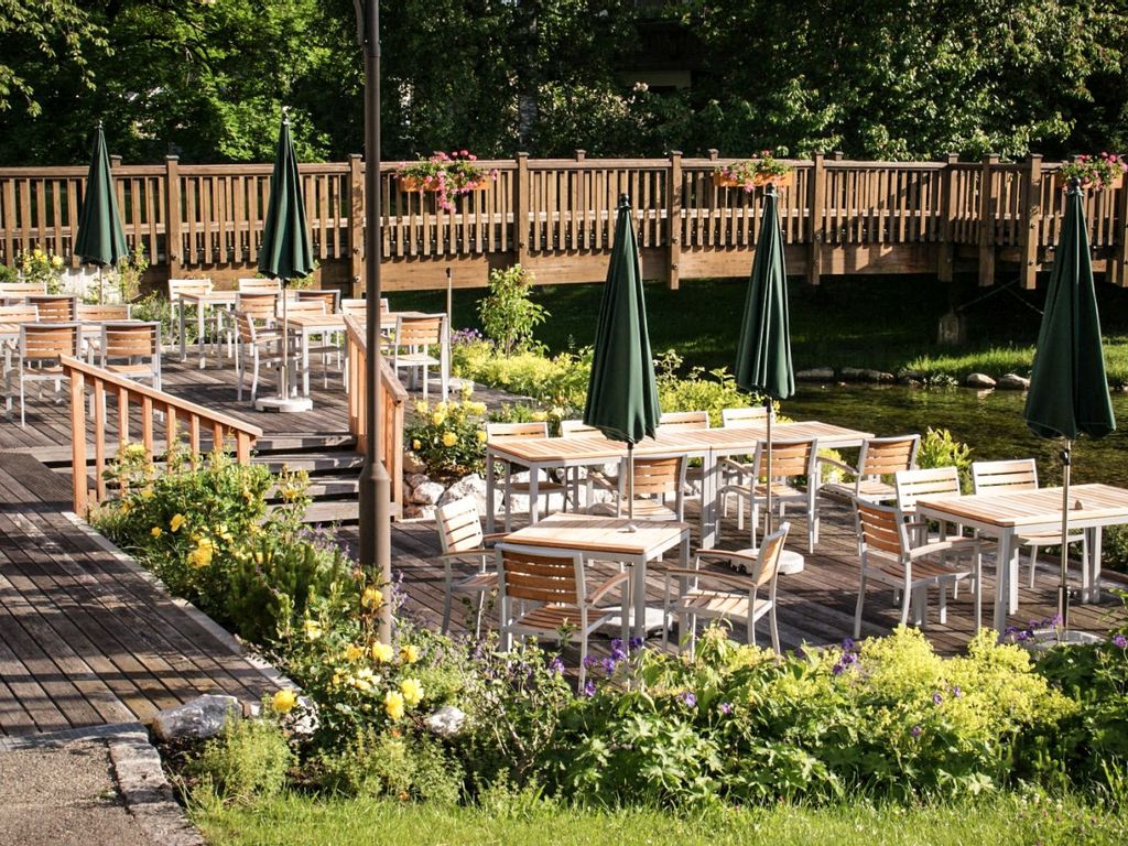 Die sonnige Außenterrasse der Speisegalerie Fischen mit gemütlichen Sitzplätzen – ein perfekter Ort, um Speisen und die frische Luft der Allgäuer Hörnerdörfer zu genießen.