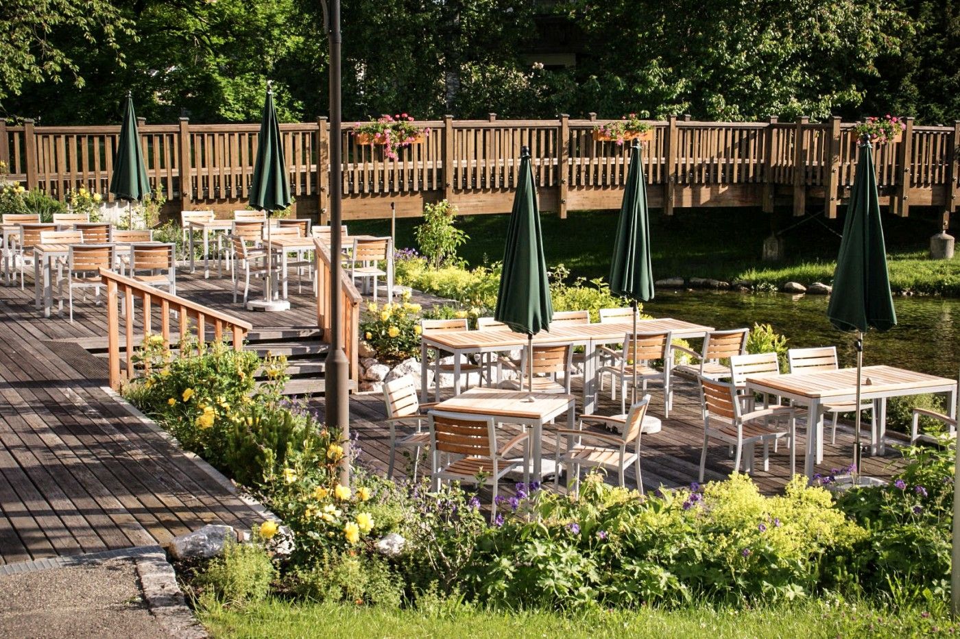 Die sonnige Außenterrasse der Speisegalerie Fischen mit gemütlichen Sitzplätzen – ein perfekter Ort, um Speisen und die frische Luft der Allgäuer Hörnerdörfer zu genießen.