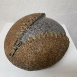 Kunstobjekt aus Stein und Metall – ein symbolischer Reißverschluss öffnet den massiven Stein und gibt den Blick ins Innere frei, ausgestellt in der Kunstausstellung „Schwäbisches Dreierlei“ im Kurhaus Fiskina in Fischen.