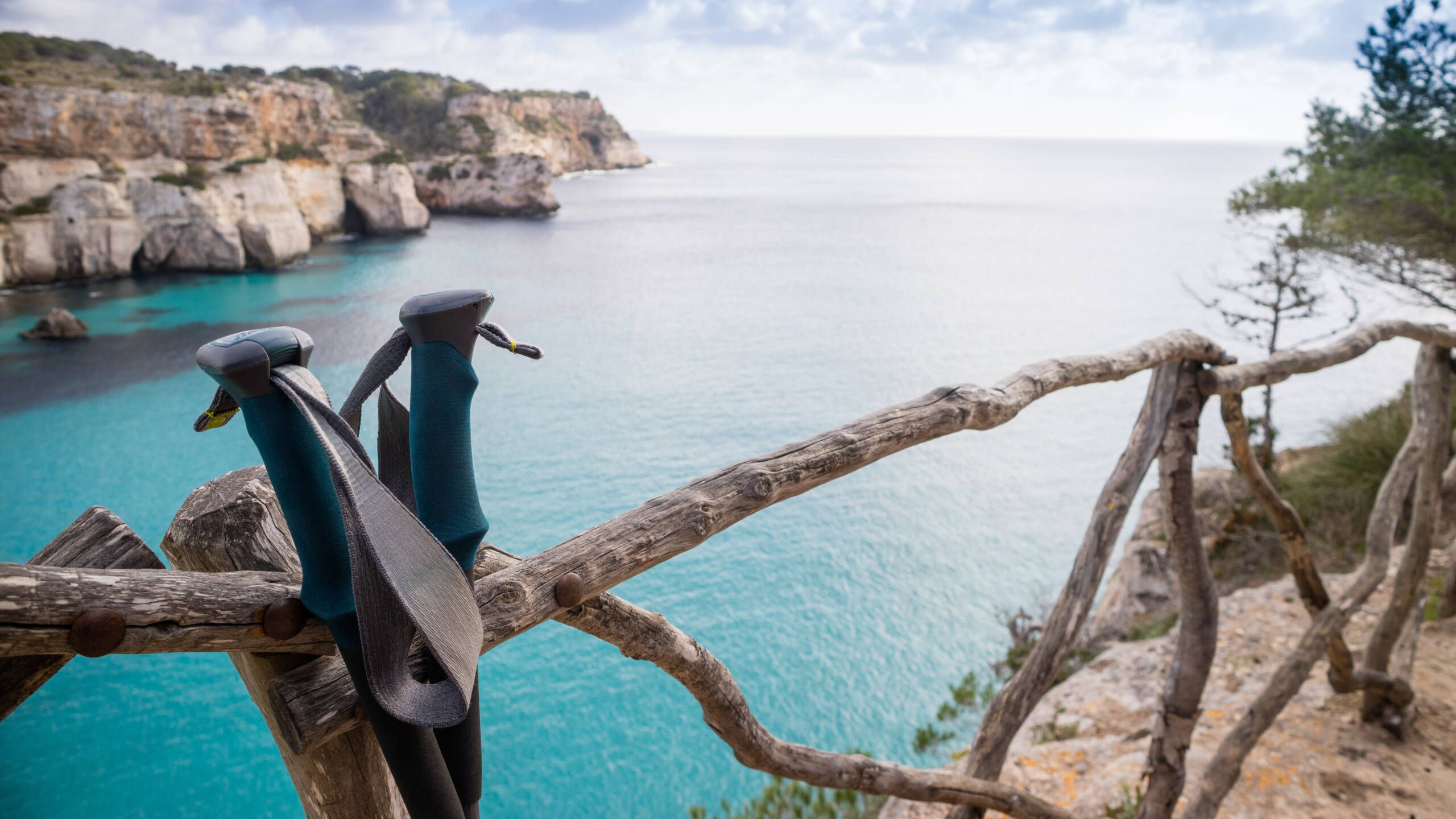blue, clear water with walking sticks in the foreground