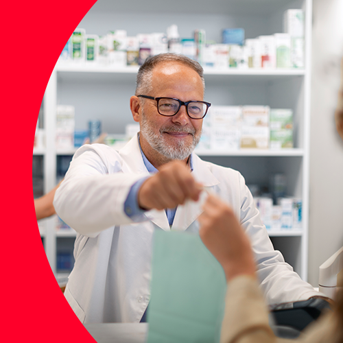 Apotheker überreicht Tüte an Kundin.