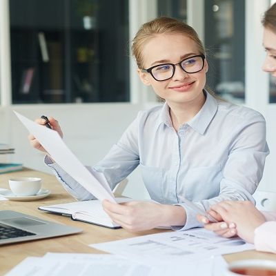 zwei Frauen beraten sich am Schreibtisch