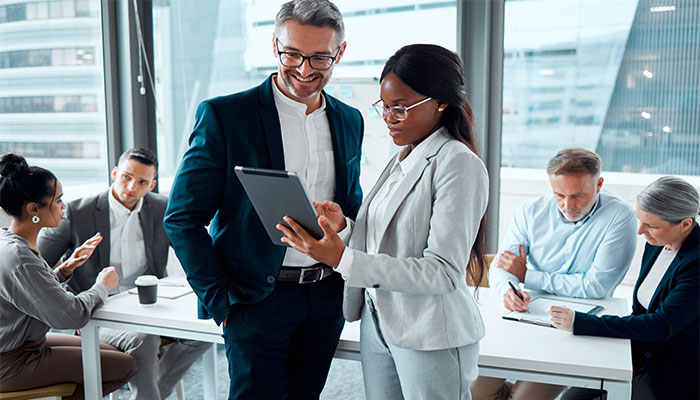 Eine weibliche Führungskraft erklärt ihren Angestellten die Funktionen des 360-Grad-Feedback-Tools.