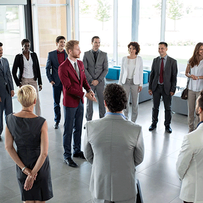 Gruppe an junger Menschen steht im Kreis und führt ein 360 Grad Feedback durch.