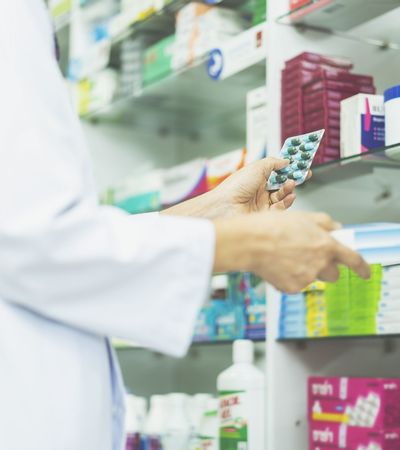 Apotheker mit Medikamenten in der Hand vor Regal Case Study