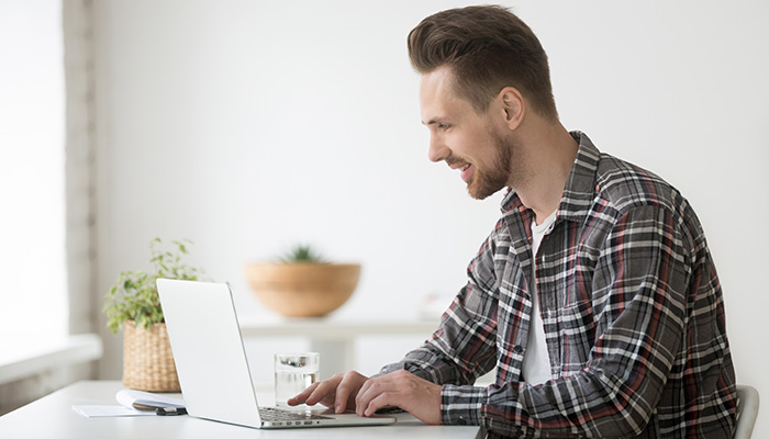 Ein Mann analysiert am Laptop das B2C-Kundenfeedback.