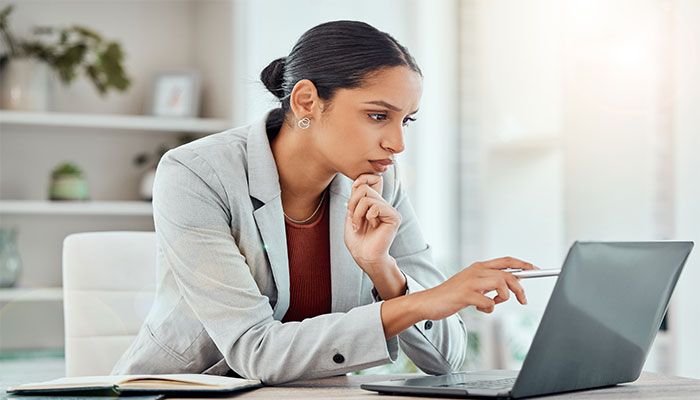 Eine Frau sitzt am Laptop und arbeitet mit der Befragungssoftware.