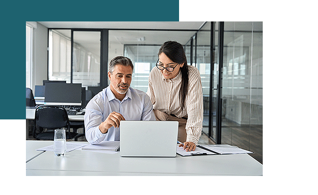 Zwei Personen diskutieren an einem Laptop über die Befragungssoftware.