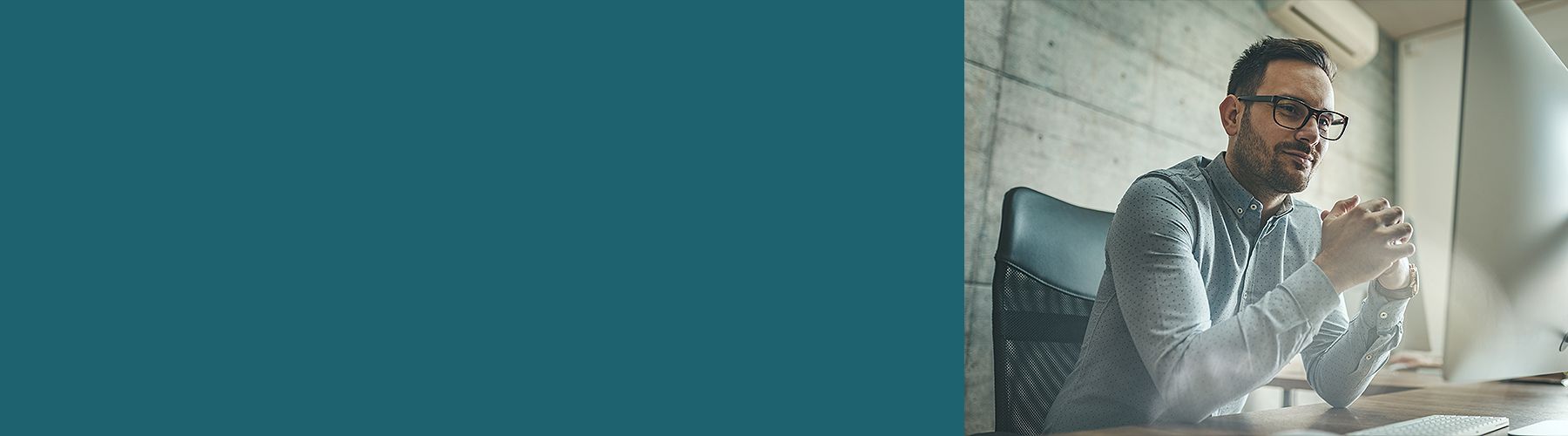 Ein Mitarbeiter schaut auf den Monitor und plant ein Führungskräfte-Training.