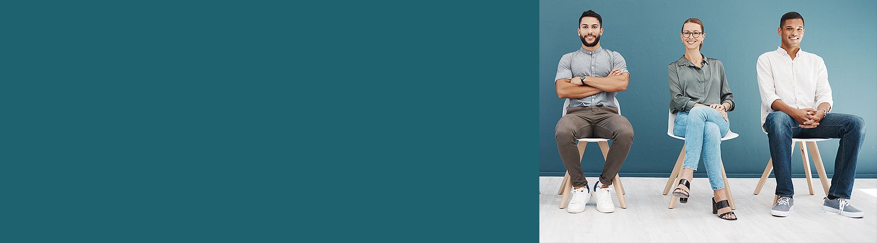 Mitarbeitende warten auf die Durchführung der Mitarbeiterbefragung und sitzen auf Stühlen.