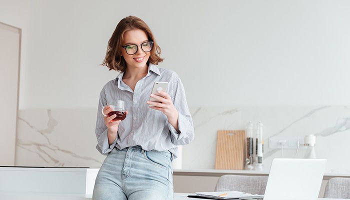 Eine Frau programmiert am Handy eine Community-Software.